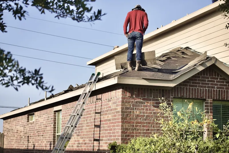 Professional roofer working on a residential roof in Beckettville